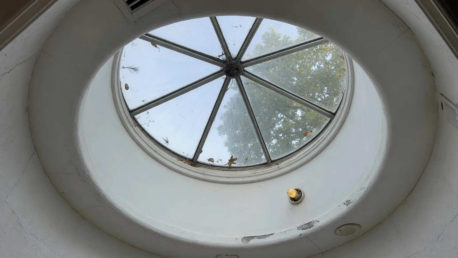 Round glass skylight in a residential ceiling well