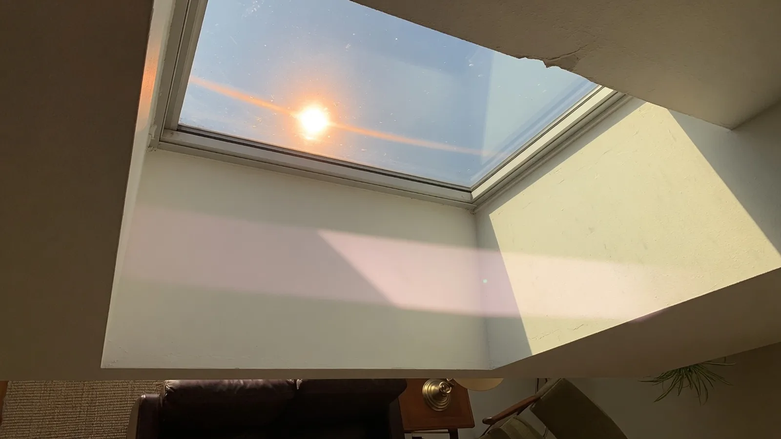 Harsh afternoon sun flooding an Austin skylight well